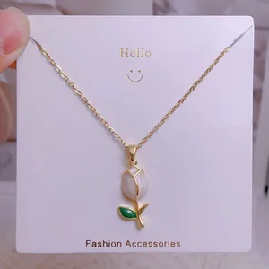 Vue détaillée du collier tulipe avec pétales blancs et chaîne dorée sur support
