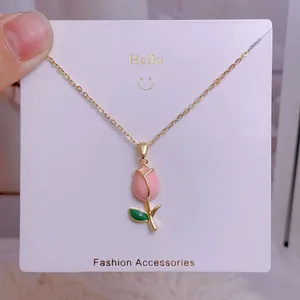 Gros plan du collier tulipe avec pétales roses et feuilles vertes sur carte de présentation