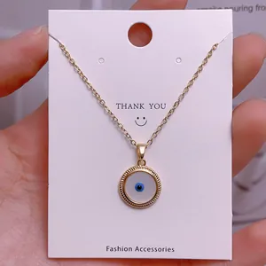 Makroaufnahme der goldenen Teufelsauge-Halskette auf einer Dankeskarte aus Schmuck