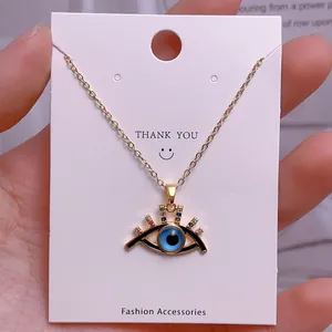 Nahaufnahme des goldenen Evil-Eye-Anhängers mit bunten Kristallen und blauem Stein