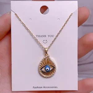Detail der goldenen Teufelsauge-Halskette mit blauer Perle und Kristallen im Tropfen-Design