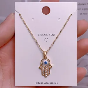 Detaillierte Makroansicht des goldenen Hamsa-Handanhängers mit Zirkonia und blauem Auge
