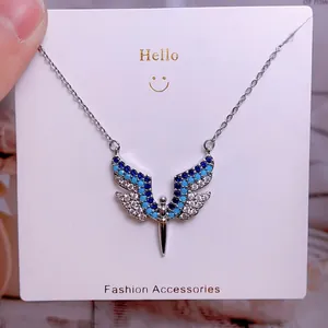 Vue détaillée du collier pendentif ailes d'ange orné de cristaux bleus et blancs