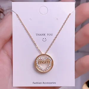 Primer plano del collar mamá de corazón dorado con diamantes en tarjeta de regalo