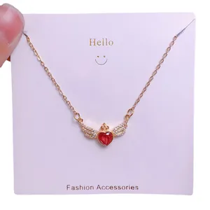 Collier en acier titane avec cœur ailé, rubis rouge et couronne sur chaîne dorée