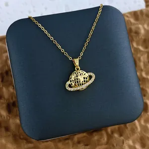 Gros plan du pendentif planète plaqué or avec oxydes de zirconium et fine chaîne croisée