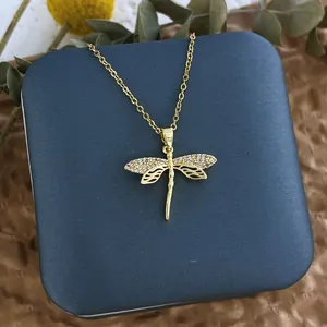 Détail du collier libellé plaqué or avec zircons sur un coffret cadeau bleu marine
