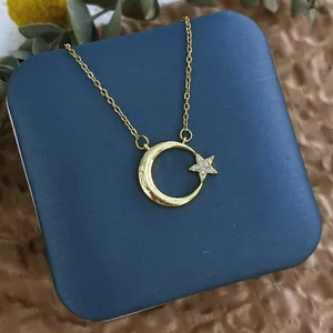 Vue détaillée du collier avec pendentif croissant de lune et étoile doré serti de zircons