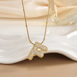 Detail of 18K gold plated letter F pendant with micro-paved sparkling cubic zirconia stones