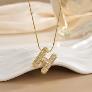 Detail of 18K gold plated letter H pendant necklace with sparkling micro-pave zircons