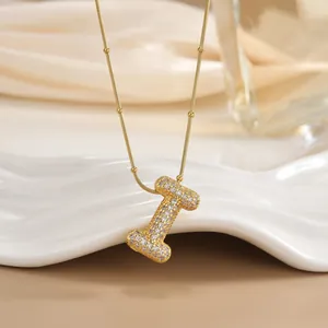 Macro shot of gold letter I pendant with micro-paved zircons on elegant snake chain