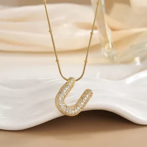 Macro shot of 18K gold plated U-shaped pendant necklace featuring pave-set cubic zirconia