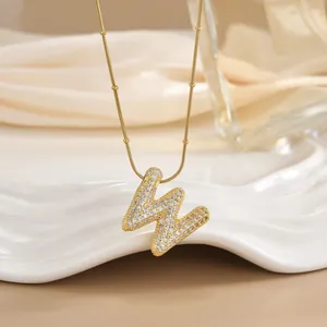 Macro shot of gold letter W pendant with micro-pave cubic zirconia on a beaded chain