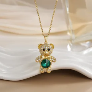 Vue détaillée d'un collier ours doré serti d'une pierre verte et de zircons blancs