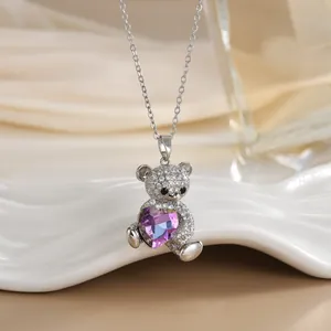 Détail d'un pendentif ours en argent avec cristal cœur violet et pierres de zircon