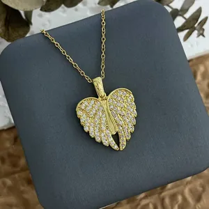 Exquisite gold heart wing necklace with micro-pave cubic zirconia on a gray display