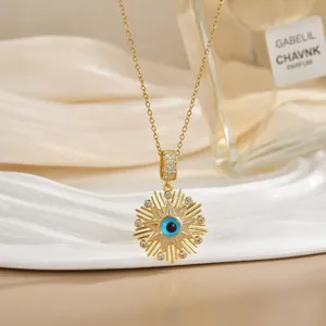 Detail of 18K gold plated evil eye pendant necklace on a decorative silk backdrop