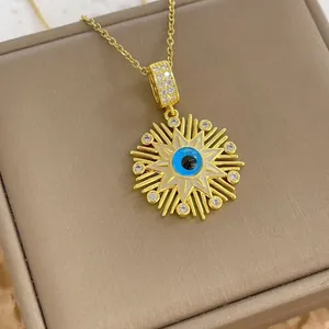 Close-up of gold Evil Eye sunburst pendant necklace with blue eye and sparkling crystals