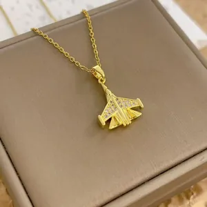 Détail d'un pendentif avion doré orné de cristaux sur un écrin de bijoux en cuir