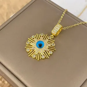 Close-up of gold Evil Eye pendant with blue inlay and zircon stones in a jewelry box