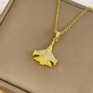 Pendentif avion de chasse doré élégant avec cristaux brillants sur un écrin bijoux