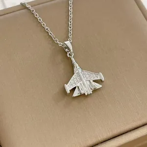 Élégant collier avion de chasse argenté avec zircons sur un coffret cadeau texturé marron