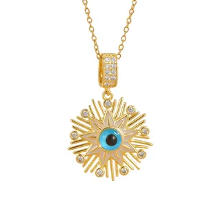 Close-up of gold starburst necklace with blue evil eye pendant and zircon stones