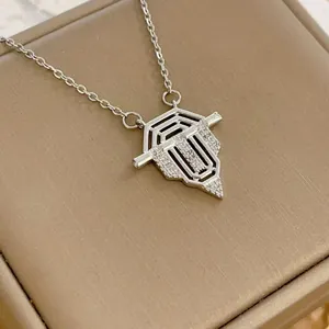 Dettaglio del ciondolo a scudo argento con micro-pavé di zirconi bianchi su catena