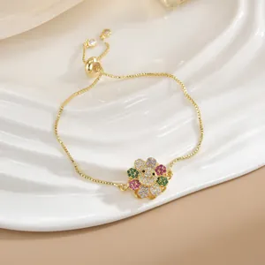 Dettaglio macro del bracciale regolabile in oro con ciondolo a girasole in zirconi colorati