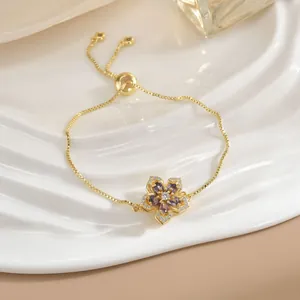 Bracciale a fiore dorato regolabile con gemma viola e dettagli in zircone lucido