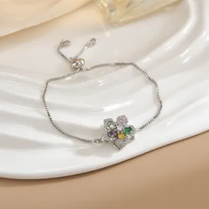 Dettaglio di bracciale a fiore regolabile con zirconi colorati e chiusura a scorrimento