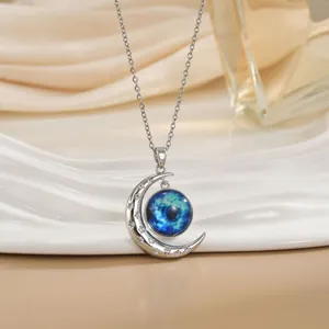 Gedetailleerd beeld van de zilveren maan hanger met blauwe galactische steen en kristallen