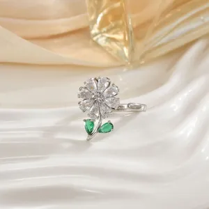 Rotating flower ring with silver band, clear zircon petals and green teardrop leaves