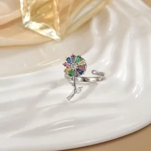 Macro detail of rotating flower ring with colorful zircon petals on white ceramic