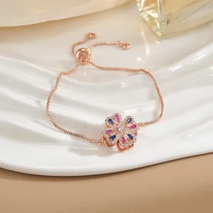 Dettaglio del bracciale a fiore in oro rosa con zirconi colorati e fibbia a scorrimento