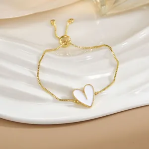 Dettaglio del bracciale a cuore dorato con chiusura a scorrimento regolabile e pendente