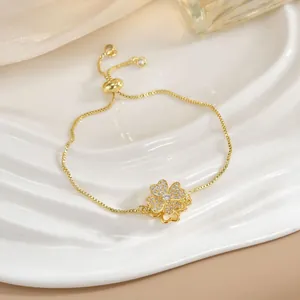 Dettaglio di un bracciale a quadrifoglio con zirconi e chiusura a scorrimento in oro
