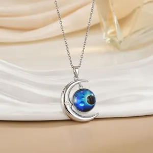 Detail van de zilveren halve maan ketting met blauwe nevelbol en stergravure
