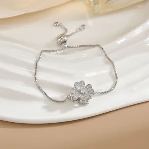 Dettaglio del bracciale a quadrifoglio in argento con zirconi su un vassoio di ceramica