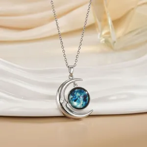 Detail van zilveren halve maan hanger met blauwe nevel glas en klein sterretje