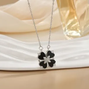 Elegant silver four-leaf clover heart necklace with black enamel and zircons on beige deco