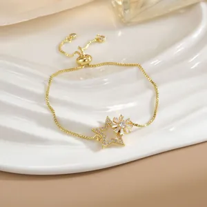 Bracciale dorato regolabile con ciondolo a stella e cristalli lucidi su vassoio bianco
