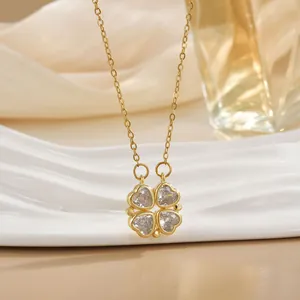 Gold clover necklace with zircon heart petals on a wave display stand, chic jewelry