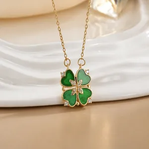 Detailed close-up of gold clover pendant with green heart petals and center crystal stones