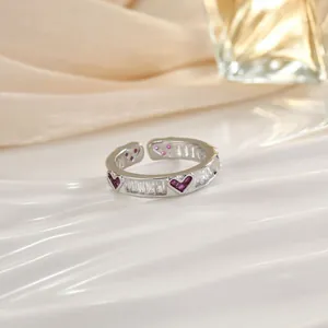 Dettaglio macro di anello a fiore regolabile con pietre a cuore viola e zirconi