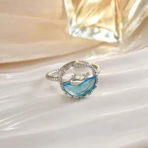 Anello balena che salta fuori dall'acqua in argento con cristallo blu e fascia ritorta