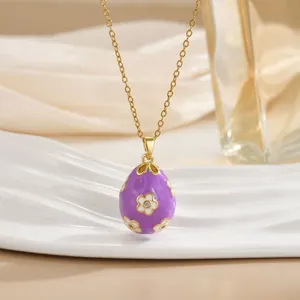 Detail of purple enamel egg pendant with gold-plated floral pattern and zircon stone