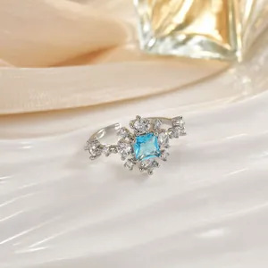 Dettaglio dell'anello a fiore in argento con zircone blu quadrato e cristalli fini