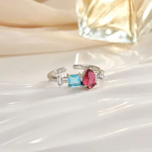 Dettaglio anello regolabile argento con gemma blu quadrata e cristallo rosa a goccia