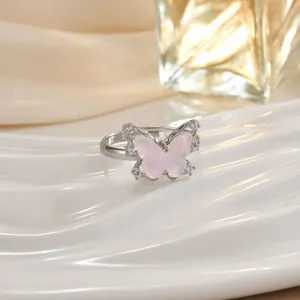 Dettaglio anello a farfalla con ali rosa e cristalli micro-pave su fascia in argento
